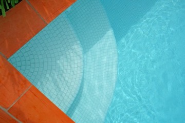 This photo of an inviting looking swimming pool was taken by an unknown photographer.